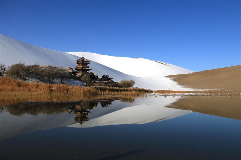 鳴沙山月牙泉景區(qū)雪景。敦煌市委宣傳部供圖，張曉亮攝