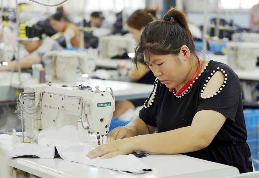 5月20日，村民在李寨村服裝加工廠內(nèi)忙碌。河南省周口市沈丘縣馮營鎮(zhèn)李寨村地處豫東平原。近年來，乘著脫貧攻堅(jiān)與鄉(xiāng)村振興政策的東風(fēng)，李寨村積極探索產(chǎn)業(yè)發(fā)展模式，通過“龍頭企業(yè)+村集體經(jīng)濟(jì)+農(nóng)戶”的方式，逐漸發(fā)展形成肉牛養(yǎng)殖、設(shè)施農(nóng)業(yè)、服裝加工、康養(yǎng)民宿等產(chǎn)業(yè)，以產(chǎn)業(yè)振興助力鄉(xiāng)村振興。新華社記者 李嘉南 攝