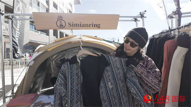 藤田周正在展示自己設(shè)計(jì)的滑雪服。人民網(wǎng)記者 袁蒙攝