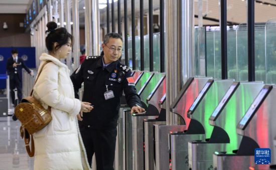 1月2日，大興機(jī)場邊檢站警察指導(dǎo)旅客使用自助出境設(shè)備。新華社記者 李欣 攝