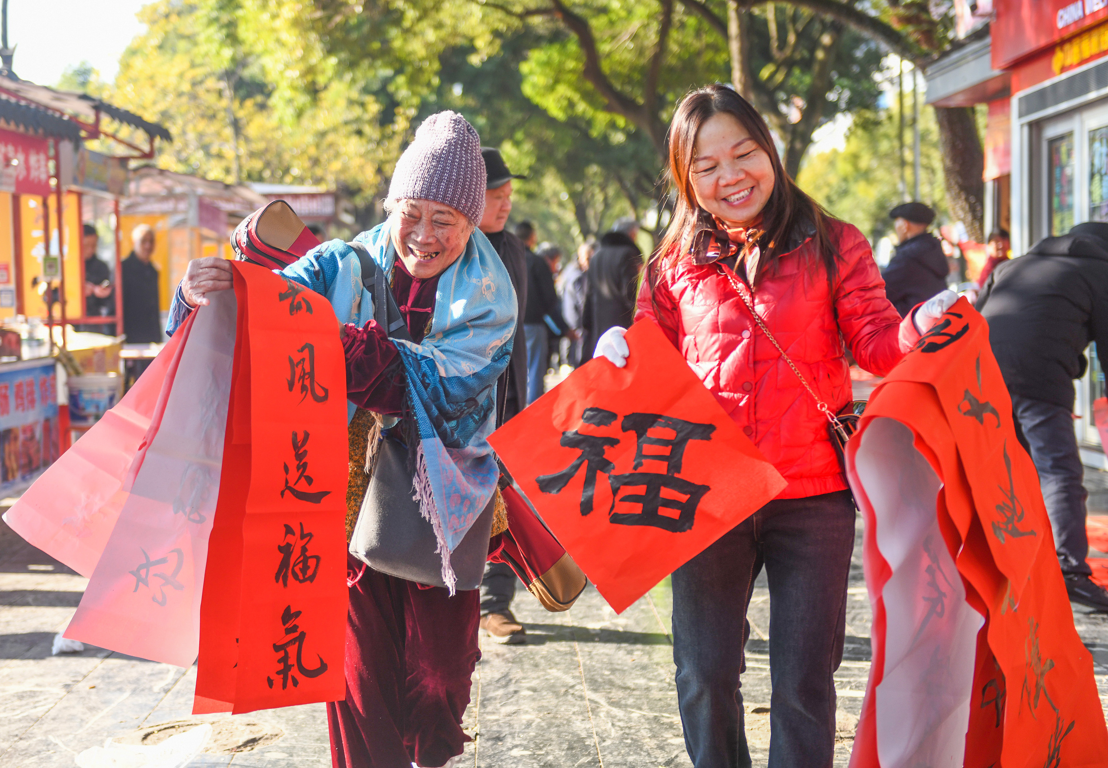 2025年1月13日，在湖南省永州市道縣西洲公園義工崗亭，市民們領到了書法志愿者為大家書寫的春聯(lián)。