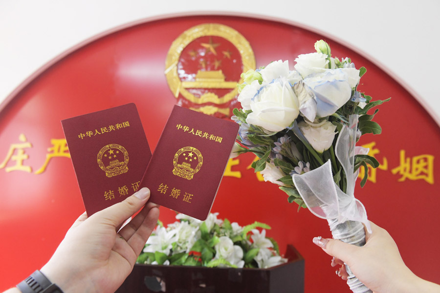 2024年8月10日，一對新人在河北石家莊新樂市民政局婚姻登記處領(lǐng)取結(jié)婚證后拍照留念。新華社發(fā)（賈敏杰攝）