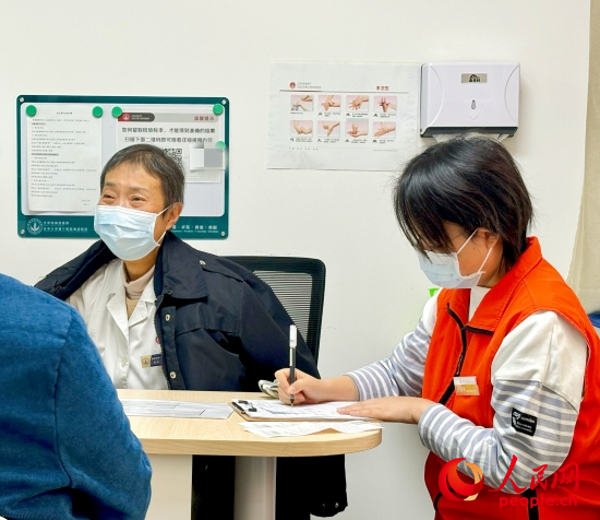 秦苑（中）接診患者。人民網(wǎng)記者 金慧慧攝