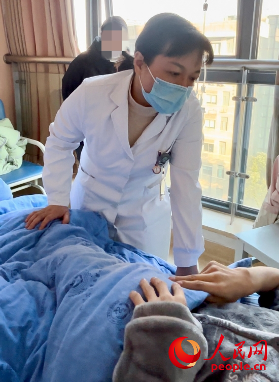 鄧茜查房時詢問患者情況。人民網(wǎng)記者 金慧慧攝