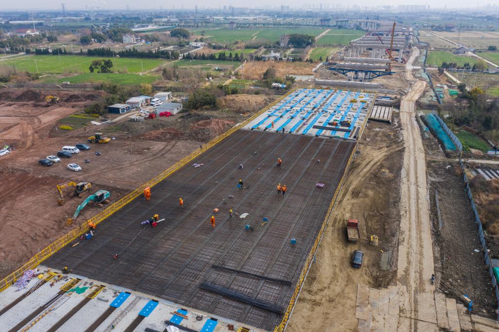 3月7日，在524國(guó)道秀洲王江涇至新塍公路工程TJ02標(biāo)段，作業(yè)人員正在進(jìn)行60米鋼混組合梁現(xiàn)澆橋面板鋼筋焊接及綁扎作業(yè)（無人機(jī)照片）。新華社記者 徐昱 攝
