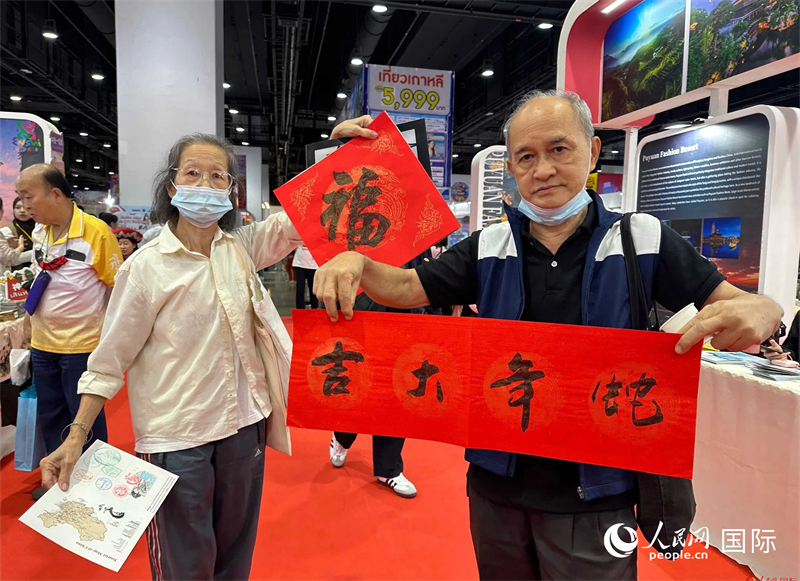 2025蛇年春節(jié)，泰國(guó)市民展示他們領(lǐng)到的華人手寫春聯(lián)。人民網(wǎng)記者 簡(jiǎn)承淵攝