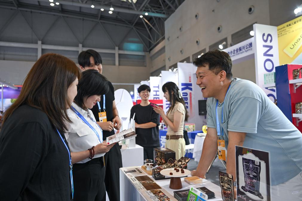 5月22日，韓國(guó)展商（右一）在西洽會(huì)現(xiàn)場(chǎng)向參觀者介紹產(chǎn)品。新華社記者 陳誠(chéng) 攝
